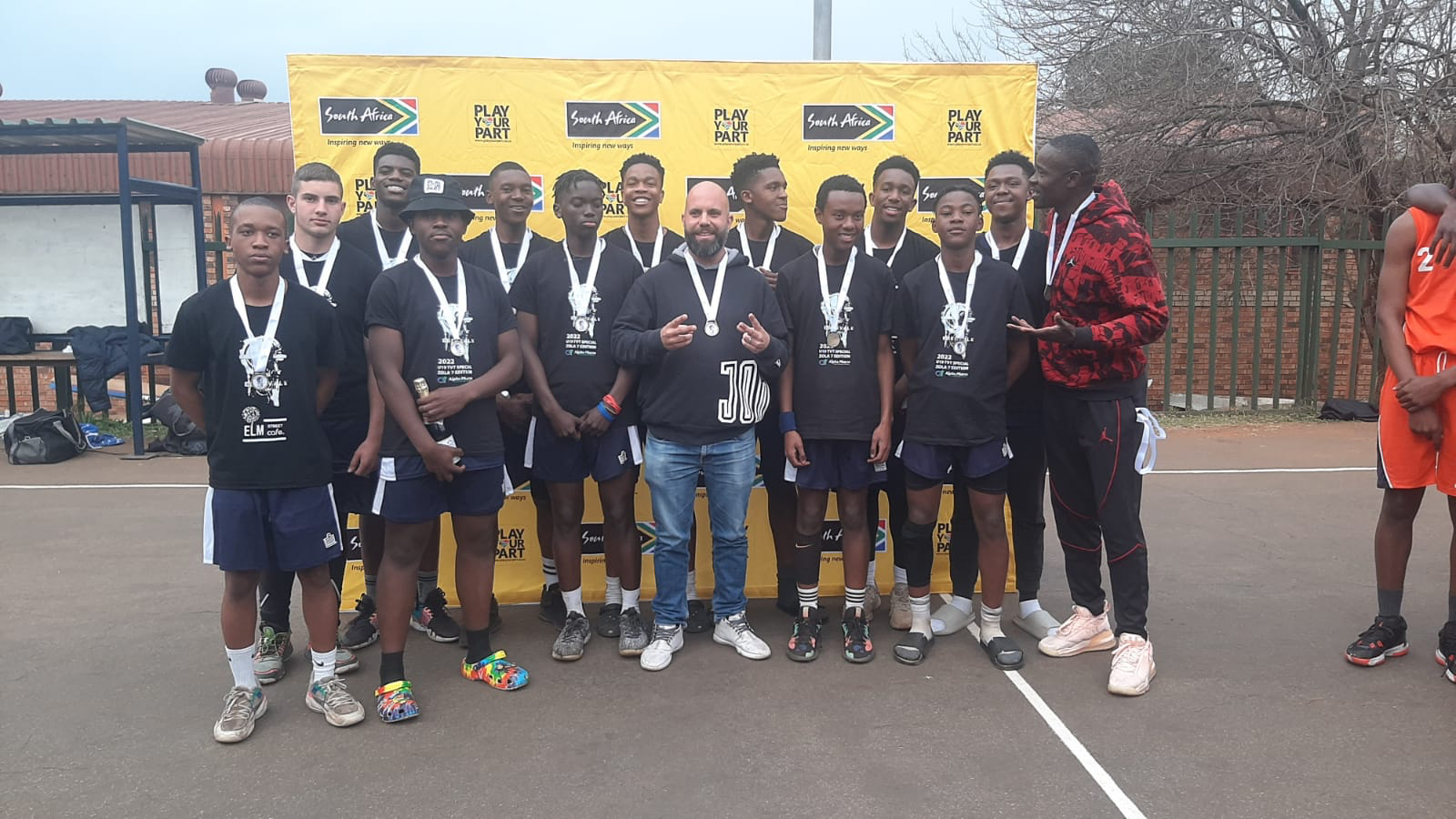 Edenvale Lions U18 players and coaches wearing medals at the 2023 TVT celebration