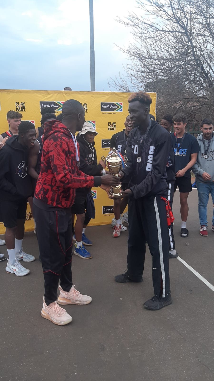 A player receives a trophy with teammates gathered around